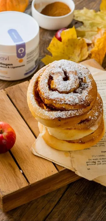 Cinnamon bun with apple and autumn decor on a wooden board.