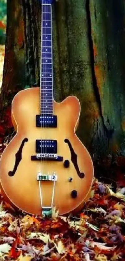 Guitar leaning against tree with autumn leaves.