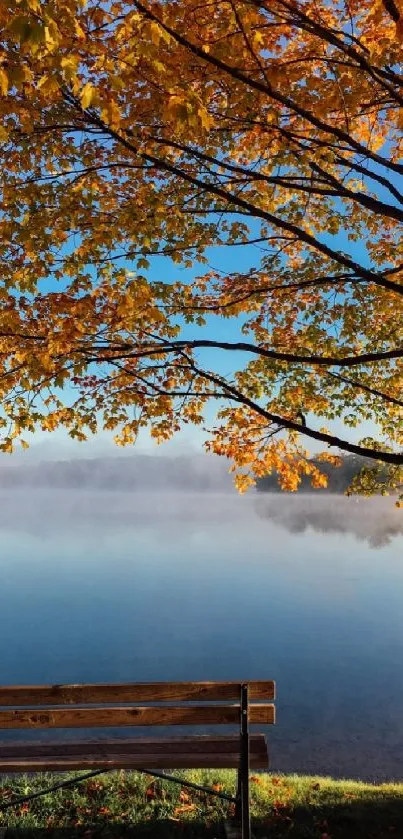 Serene autumn lake view with a bench and orange leaves.