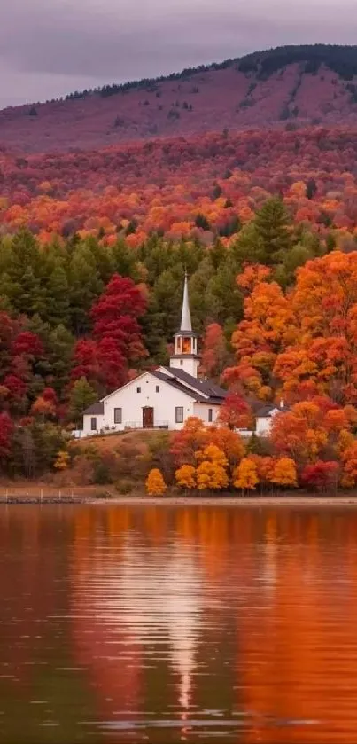 A picturesque church by a lake during autumn with vibrant orange foliage.