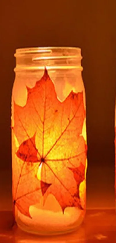 Glowing candles in jars with autumn leaves creating a warm ambiance.