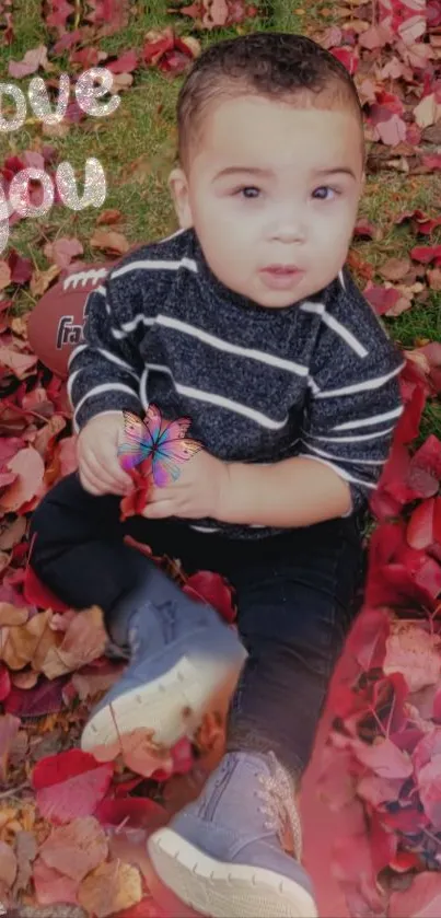 Baby playing among autumn leaves with 'love you' message.