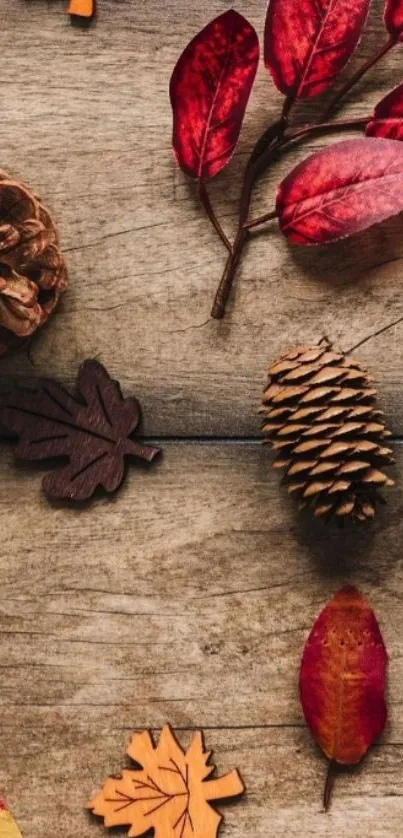 Autumn leaves and pinecones on wood background wallpaper.