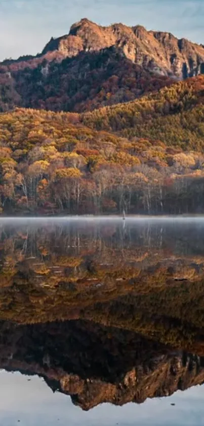 Mountain and autumn foliage reflected in calm lake.