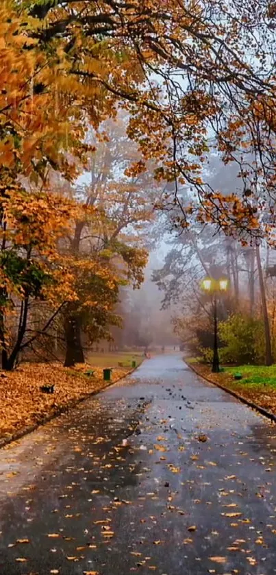 Autumn pathway with golden leaves and light fog on a serene day.