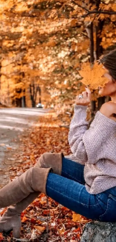 Woman holding leaf on autumn path, surrounded by fall colors.