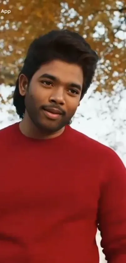 Person in red sweater with fall leaves background.