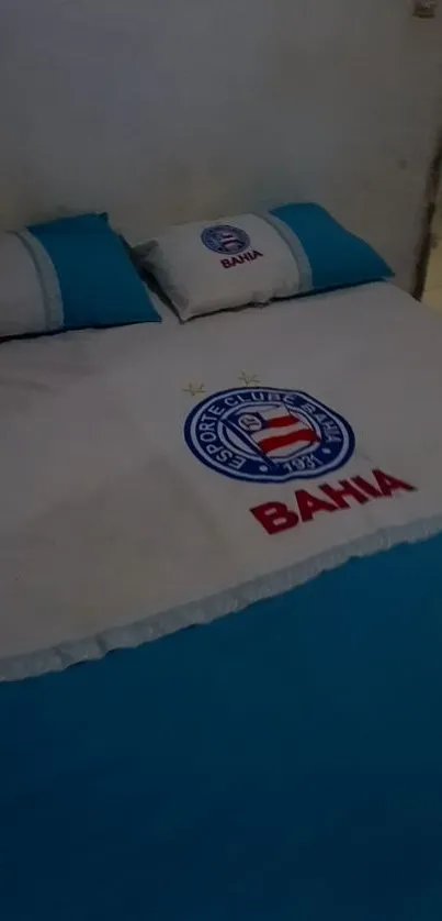 Bahia-themed bed with logo and blue pillows.