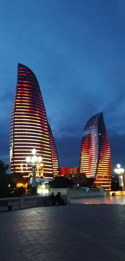 Baku's Flame Towers illuminated at night against a dark blue sky.