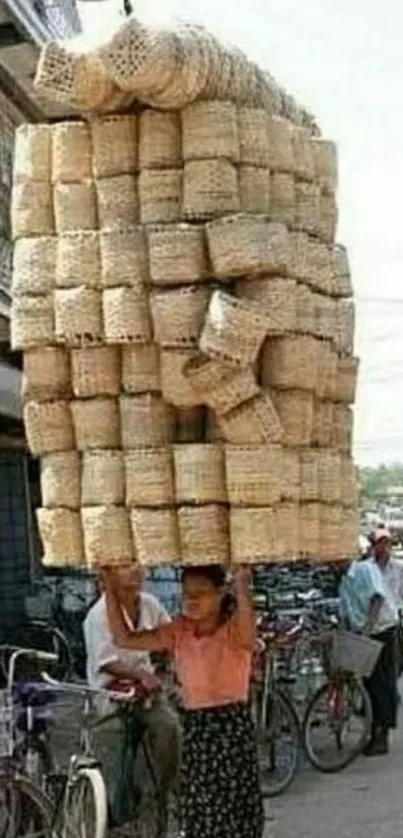 Person balancing large stack of baskets on street.