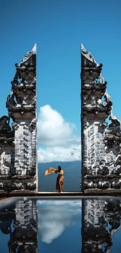 Balinese temple with clear sky and reflection on water.