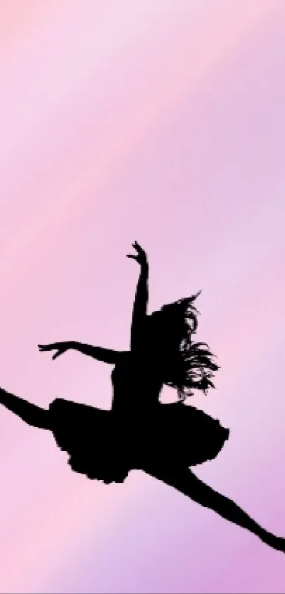 Silhouette of ballet dancer leaping on pastel pink and purple background.