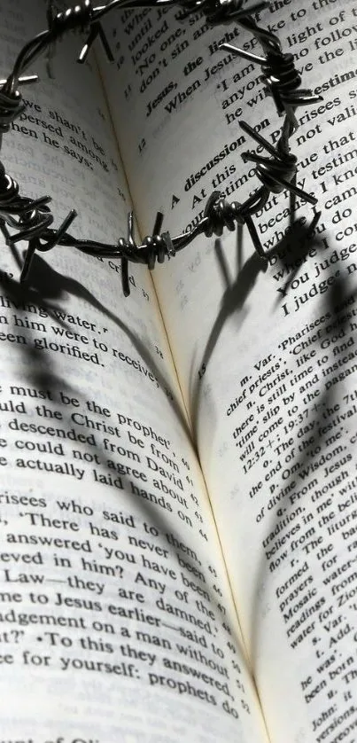 Barbed wire forming heart shadow on book pages.