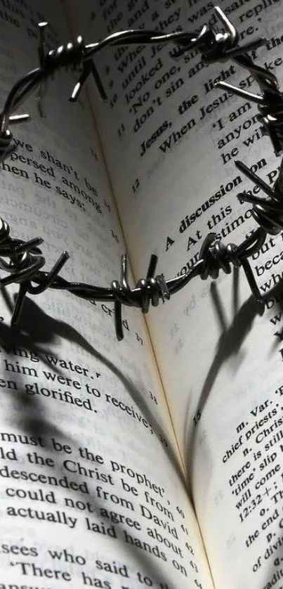 Barbed wire heart casting a shadow on an open book.