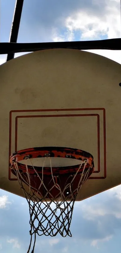 Basketball hoop with blue sky and clouds in the background.