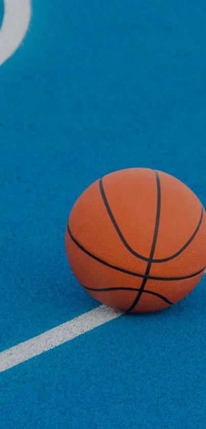 Orange basketball resting on a blue court surface.