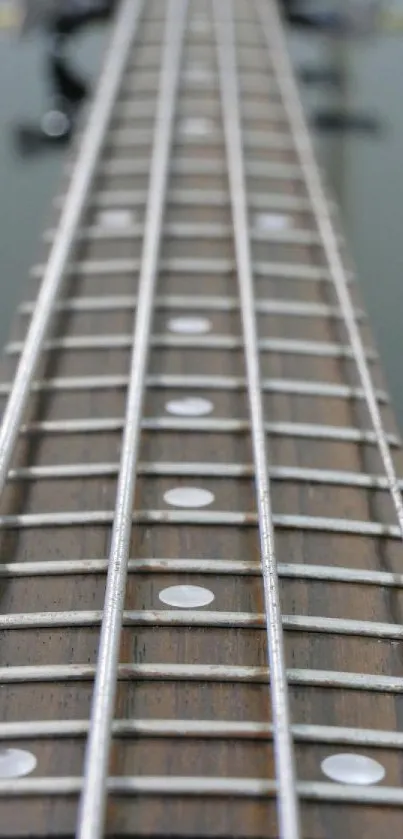 Close-up of a bass guitar neck with strings and frets in focus.