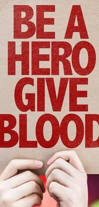 Hands holding a sign with "Be a Hero, Give Blood" in red text.