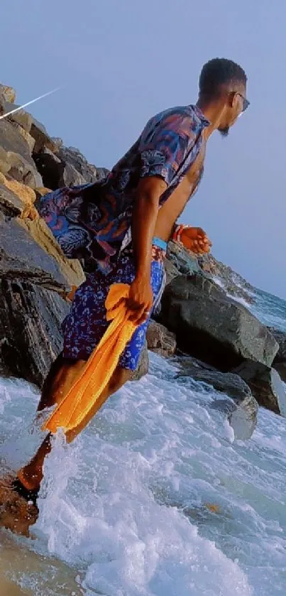 Man exploring rocky beach with ocean waves.