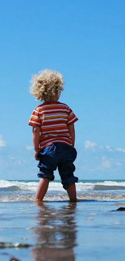 Child enjoys beach with bright blue sky and waves, perfect for serene mobile wallpaper.