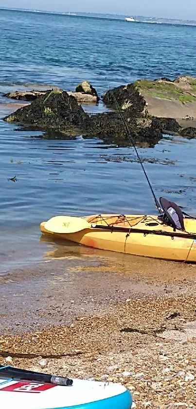 Serene beach with kayak and paddleboard on sandy shore.