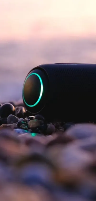 Mobile wallpaper with glowing speaker on a pebbled beach at sunset.