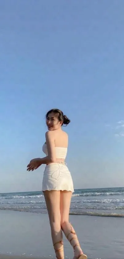 Woman enjoying a serene beach under a clear blue sky.