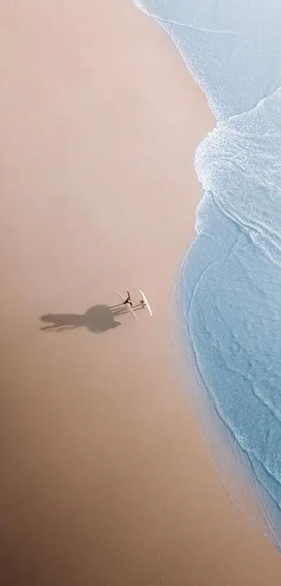 Aerial view of a serene beach with gentle waves meeting the sandy shore.