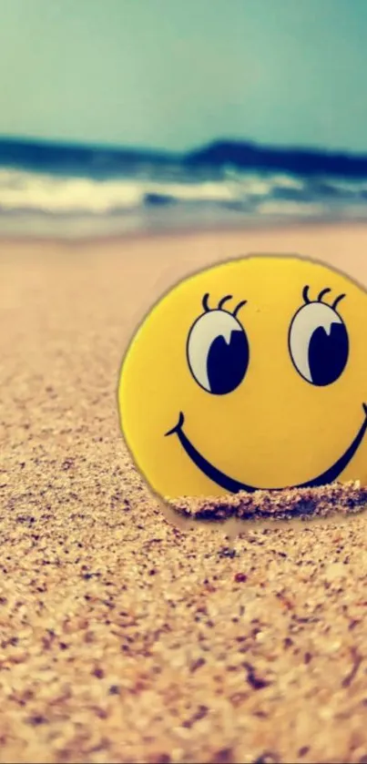 Smiley face on a sandy beach with a blue ocean background.