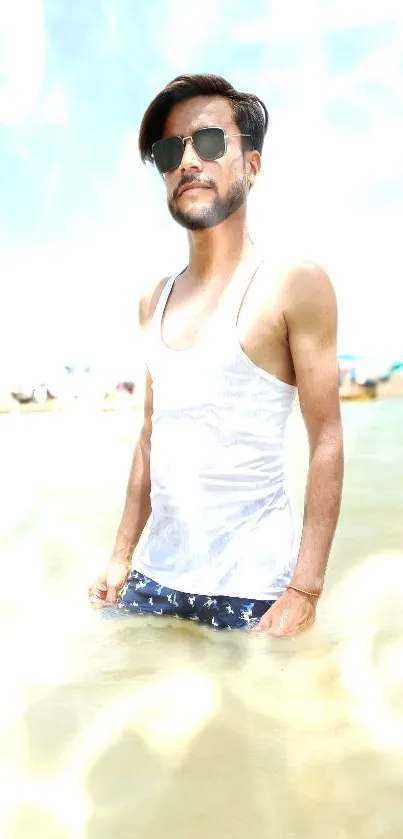 Man in water wearing sunglasses on a sunny beach day.