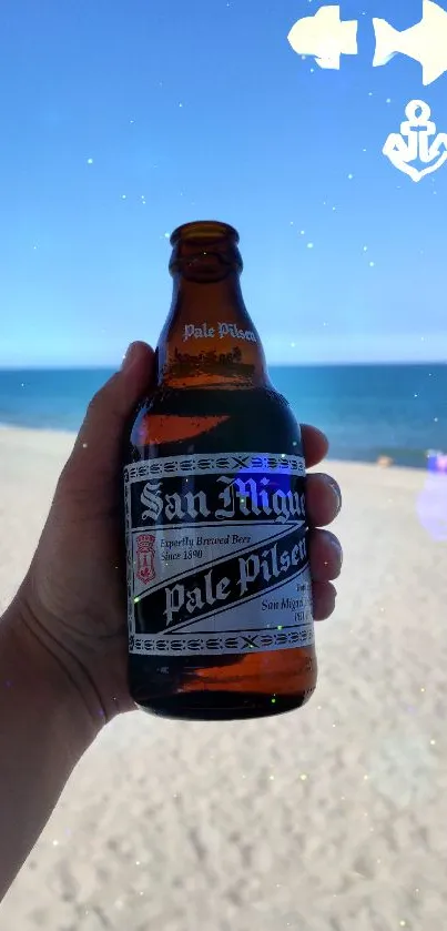 Hand holding a beer bottle on a sunny beach background.