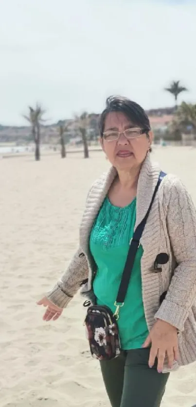 Woman enjoying a sunny beach walk with palm trees and clear skies.