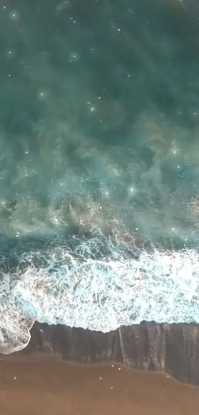 Aerial view of ocean waves meeting the sandy beach.