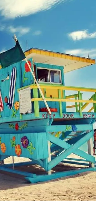 Vibrant lifeguard tower on sunny sandy beach under blue sky.