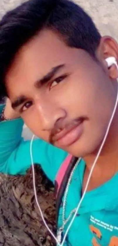 Young man at beach with earphones, vibrant portrait.