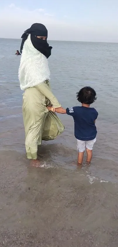 Parent and child at the beach, enjoying the ocean view.