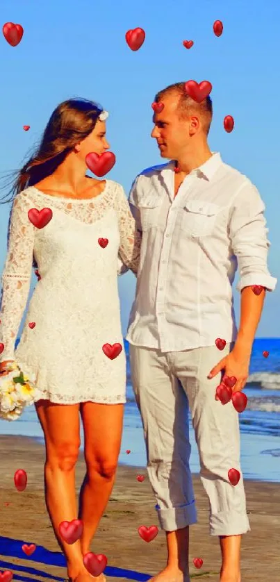 Couple walking on beach with ocean backdrop.