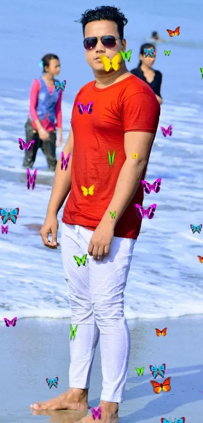 Man in red shirt on a serene beach with blue ocean waves.