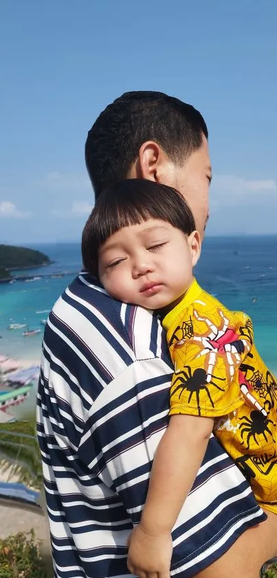 A parent holds a child by the beach, overlooking a serene coastal view.