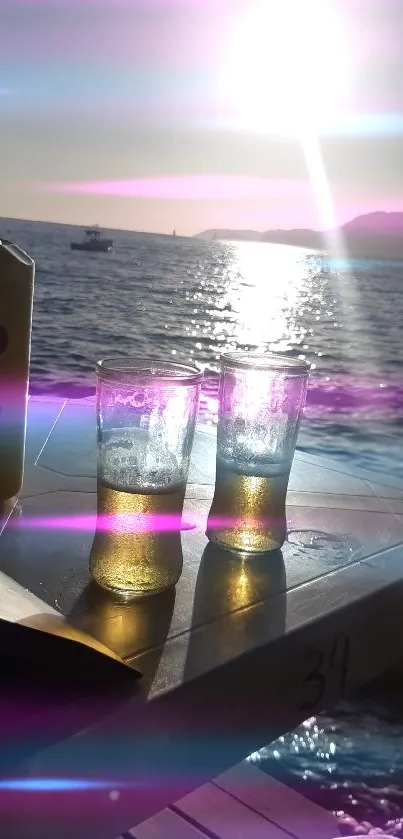 Golden sunset over the ocean with drinks on a beachside table.