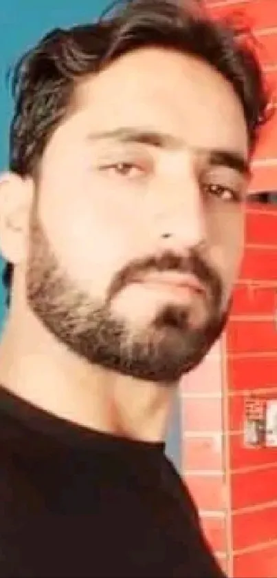 Bearded man with focused look against red background.