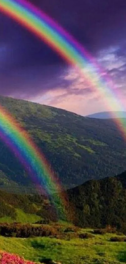 Vivid double rainbow over green mountains under purple skies.