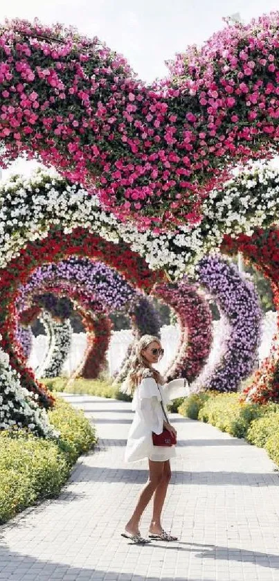 Girl walking through flower heart arches in a garden.