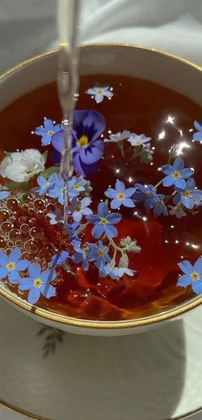 Cup of tea with blue flowers floating gently.