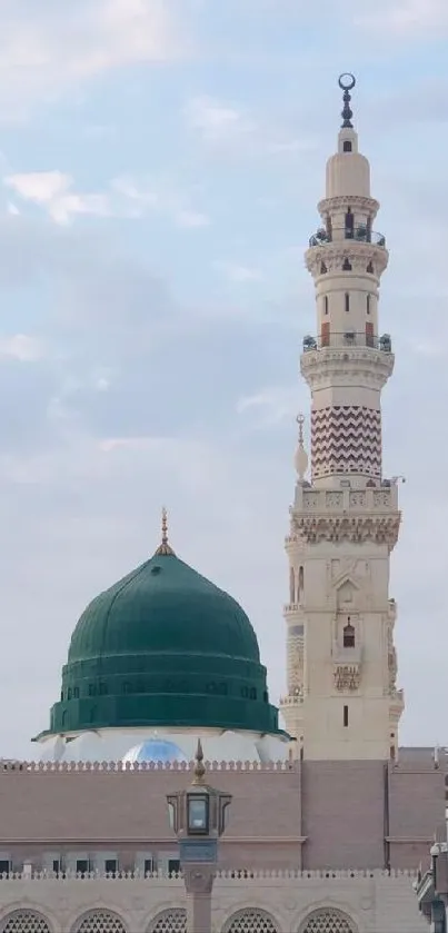 Beautiful mosque with green dome and tall minarets under a cloudy sky.