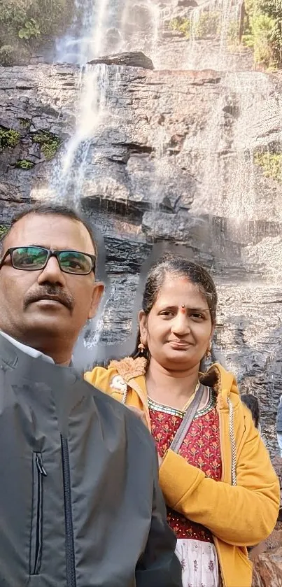 Peaceful waterfall with lush green surroundings and rocky landscape.