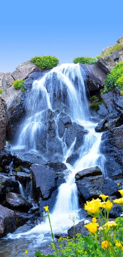 Serene waterfall flowing over rocks with vibrant flowers in the foreground.