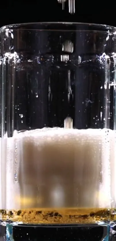 Beer being poured into a clear glass with frothy bubbles.