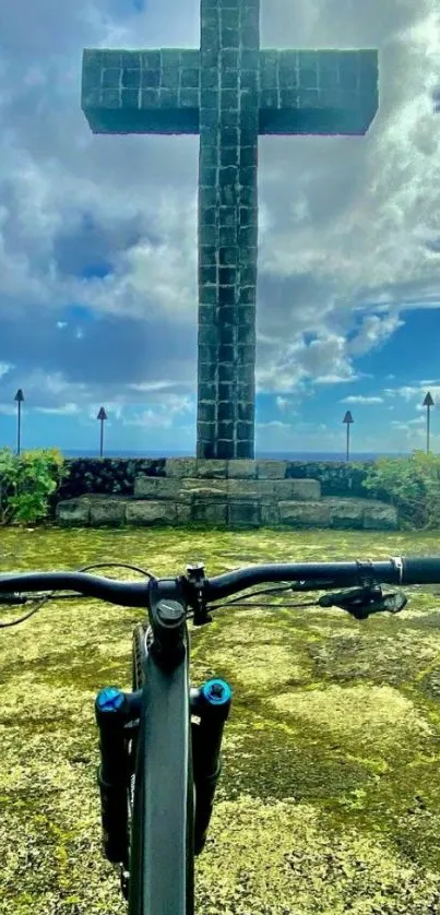 Bicycle parked near a large cross with a vibrant sky backdrop.