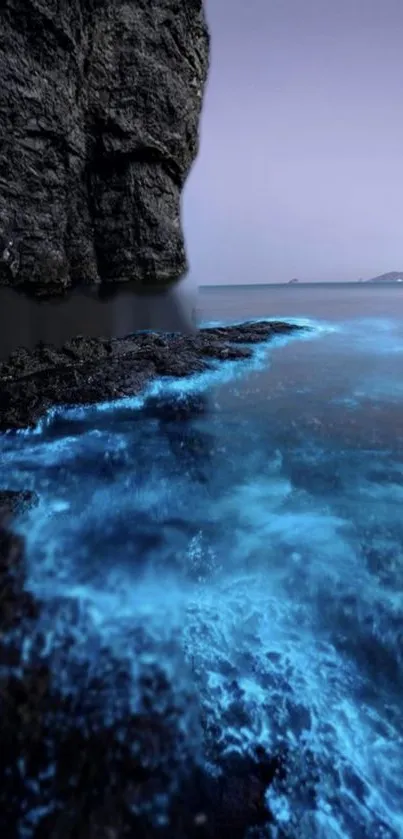 Bioluminescent ocean with glowing blue water by sea cliffs under a twilight sky.